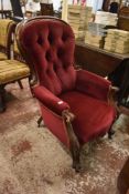 A Victorian deep buttoned spoon back easychair. with scrolling frame and burgundy upholstery. Seat