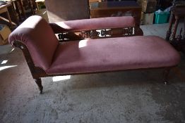 A Victorian oak show frame chaise longue, the exposed frame profusely carved and pierced, raised