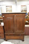 An Edwardian mahogany wardrobe with dentil moulded cornice over a plain freeze, the panelled doors