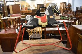 A Vintage child's cast metal rocking horse with sprung action, marked Made in England. 90CM.