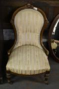 A late Victorian upholstered nursing chair with striped material, incised decoration, and turned and