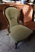 A late Victorian mahogany spoon back nursing chair, upholstered in light green Dralon and raised