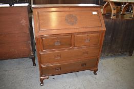A 20th century Chinese hardwood bureau of traditional arrangement with carved roundel decoration and