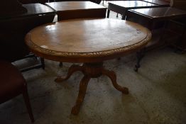 A Victorian carved and inlaid pedestal loo table, quarter veneered with central inlaid oval