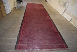 A length of machine loomed carpet decorated with repeating fleur-de-lis design. 482CM.