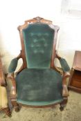 A Victorian mahogany upholstered easy chair with tapering, carved and buttoned back, partially