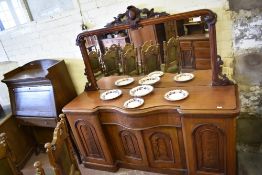 A Victorian mahogany serpentine fronted mirror back sideboard, the large mirror with scrolled carved