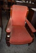 A Victorian mahogany easy armchair with shaped back, over partially padded arms with spindle