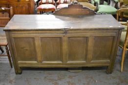 An 18th century oak four panel coffer, having a planked rectangular top over incised rails, the