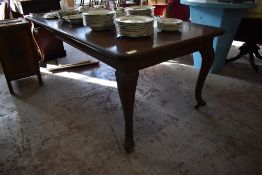 A 1920s mahogany extending dining table of traditional design, with moulded edge detail, cabriole