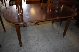 An early 20th century mahogany extending dining table, of rounded rectangular form raised on