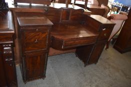 A Regency period mahogany sideboard of small proportions, with scrolled tablet back over a sunken