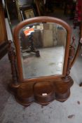 A Victorian mahogany swing dressing mirror with arched and bevelled mirror over turned supports