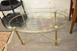 A 20th century brass and glass coffee table, the fluted supports linked by an X form stretcher. 52