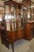 An Edwardian banded mahogany display cabinet, having a slender moulded cornice and geometric