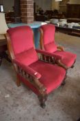 A pair of Victorian mahogany his and hers easy chairs, upholstered in deep red material, each with