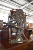 A 19th century rustic spinning wheel, the platform having remains of incised ownership, some old