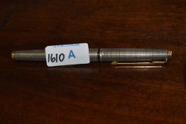 A Sterling silver fountain pen, having geometric textured surface and gilt embellishments.