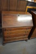 A reproduction mahogany bureau of traditional design, with four long drawers raised on short claw