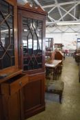 An astragal glazed mahogany double corner cupboard, having an urn topped surmount over plain
