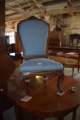 A Victorian rosewood framed nursing chair, the spoon shaped back with padded upholstery and carved