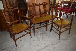 An Edwardian stained wood three piece salon suite, comprising a two seater settee and two armchairs,