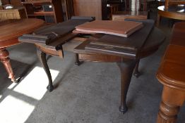 A 1920s mahogany extending dining table with D shaped ends and two additional leaves, and raised