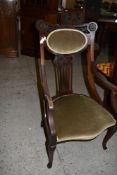 An Art Nouveau mahogany armchair, with foliate carved and pierced detail, pierced central splat over