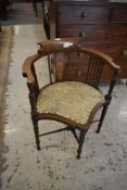 An Edwardian inlaid mahogany corner armchair with padded seat and turned supports