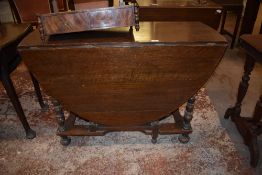 A 20th century reproduction oak gateleg table, having bobbin turned supports and beaded detail.