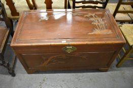 A 20th century Chinese carved camphorwood blanket box, decorated with bamboo and blossoms 104CM.