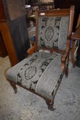 A Victorian oak framed easychair, with incised rails and patterned foliate upholstery seat height.