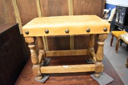 A 20th century leather topped stool, the leather top with oversized studs, over the balluster turned