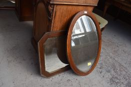 Two early 20th century mahogany wall mirrors, one of canted rectangular form, the other oval.