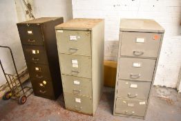 A group of three vintage metal filing cabinets