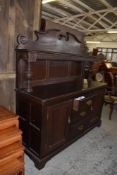 A Victorian oak sideboard, having raised Swan Neck pediment over guilloche carved shelf frieze