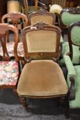 A pair of Victorian oak upholstered chairs, with carved and moulded decoration, the slightly bowed