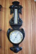 A Victorian carved and stained oak barometer, having thermometer scale over circular barometer dial,