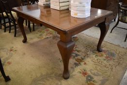 An early 20th century mahogany extending dining table with moulded edge detail and bulbous cabrial