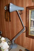 A grey painted angle poise lamp of traditional design.