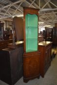 A slender reproduction mahogany double corner cupboard with dentil molded over green painted