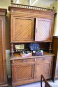 A Victorian pitch pine aesthetic period two stage sideboard, having spindled surmount over moulded