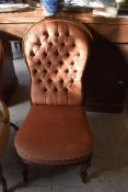 A Victorian carved mahogany nursing chair, the arched back with well carved foliate crest over the