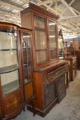 An Edwardian mahogany bookcase, the upper stage with moulded cornice above plain glazed doors, the