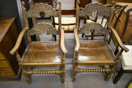 A pair of reproduction oak Derbyshire style armchairs, with typical domed rails, solid seats,