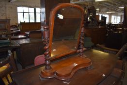 A Victorian mahogany swing dressing mirror with barley twist turned uprights and shaped platform.