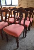 A set of six Victorian mahogany dining chairs with arched backs and carved and pierced central