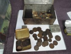A metal tin containing World Coins and GB 19th/18th Century Tokens along with badges, silver