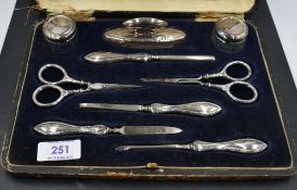 A cased George V silver mounted manicure set, complete, the silver mounts with marks for