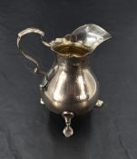 A George V silver cream jug, of baluster form with scrolled handle, generous spout and three trefoil
